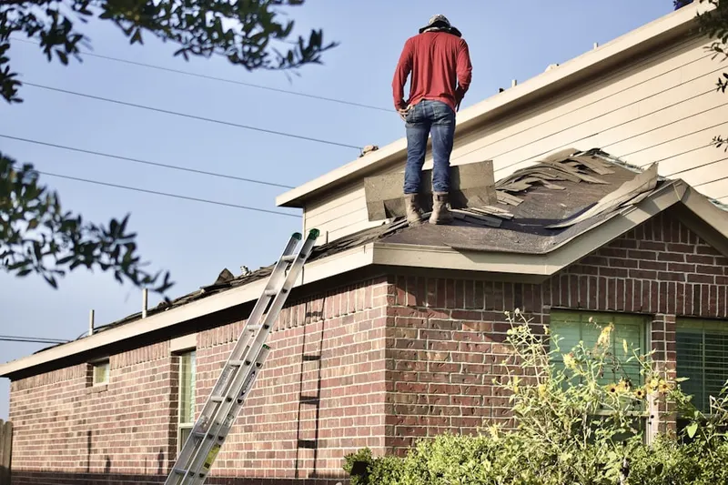 Professional roofer working on a residential roof in Cushing